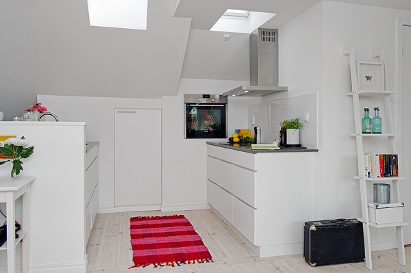 Trên tông nền trắng tinh khôi, chiếc thảm đỏ là điểm nhấn vượt trội nhất cho không gian bếp. 