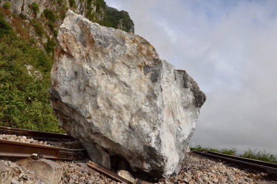 Mưa lớn, nhiều tảng đá trăm tấn rơi xuống chắn ngang đường sắt - Ảnh 1.