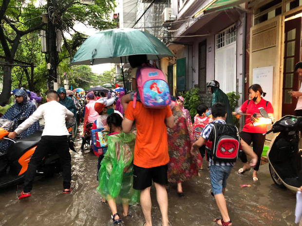 Ảnh: Cơn mưa xối xả đổ xuống Hà Nội giờ tan học khiến nhiều phụ huynh, học sinh mệt nhoài trên đường về nhà - Ảnh 2.