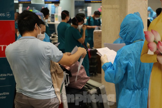 Hành khách mặc bảo hộ kín mít đến sân bay Tân Sơn Nhất ngày đầu thí điểm bay nội địa  - Ảnh 2.