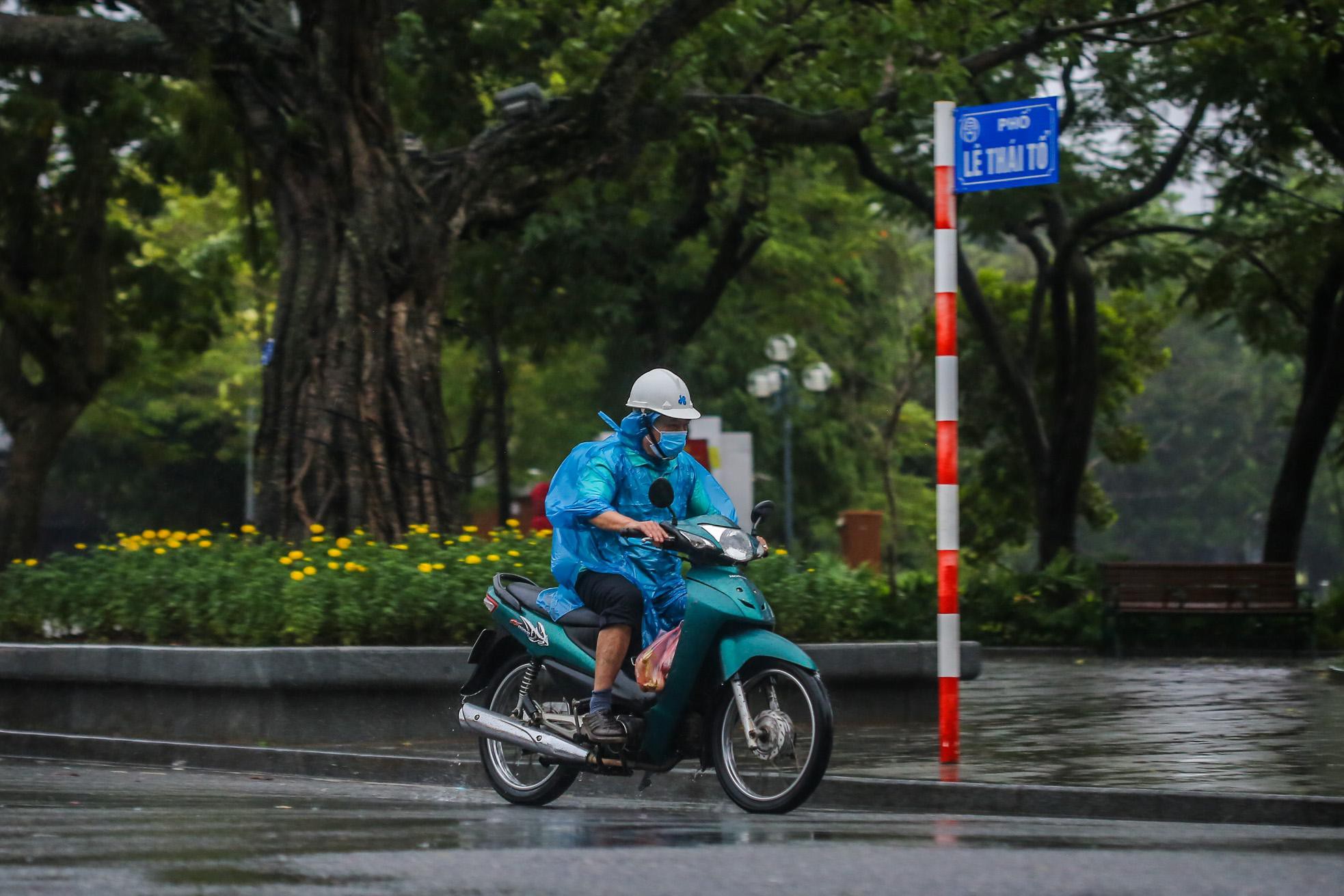 Người dân Thủ đô đón cái lạnh đầu mùa kèm mưa - Ảnh 7.