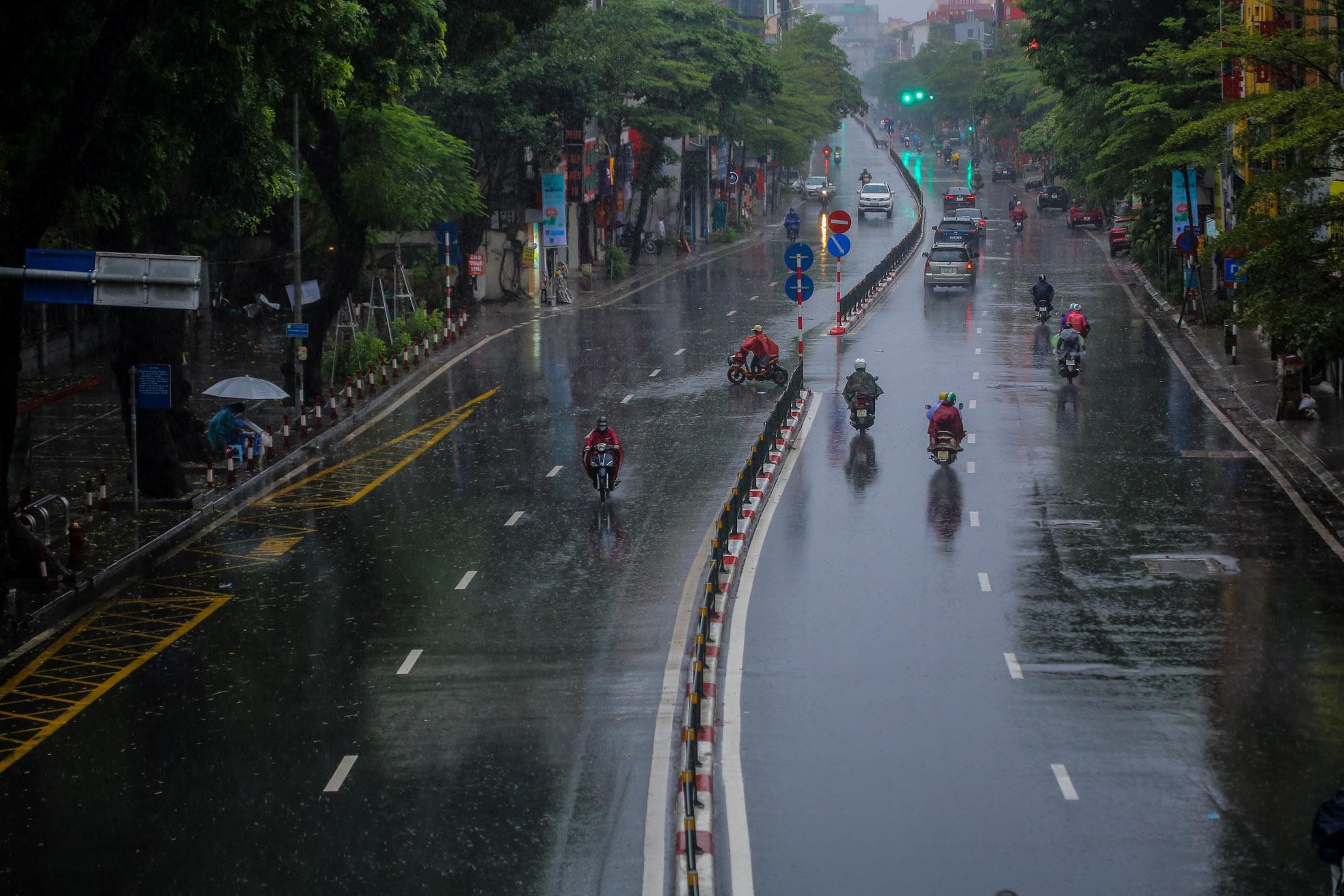 Người dân Thủ đô đón cái lạnh đầu mùa kèm mưa - Ảnh 9.