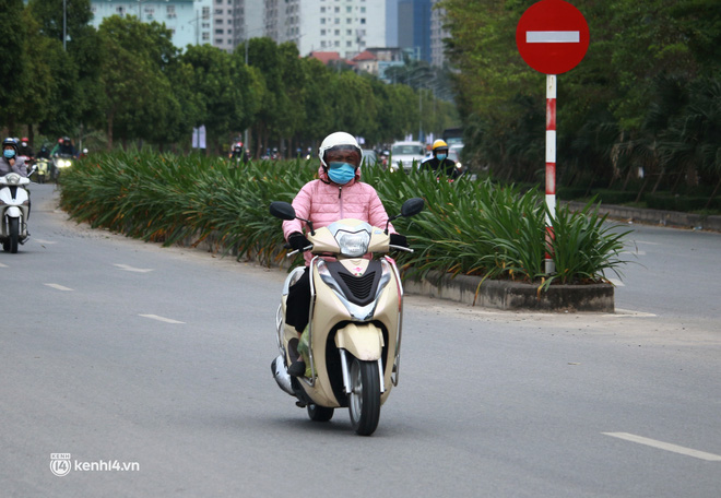 Hà Nội: Không khí lạnh bao trùm sáng đầu tuần, người dân phải mặc thêm áo mưa chống rét dù trời tạnh ráo - Ảnh 12.