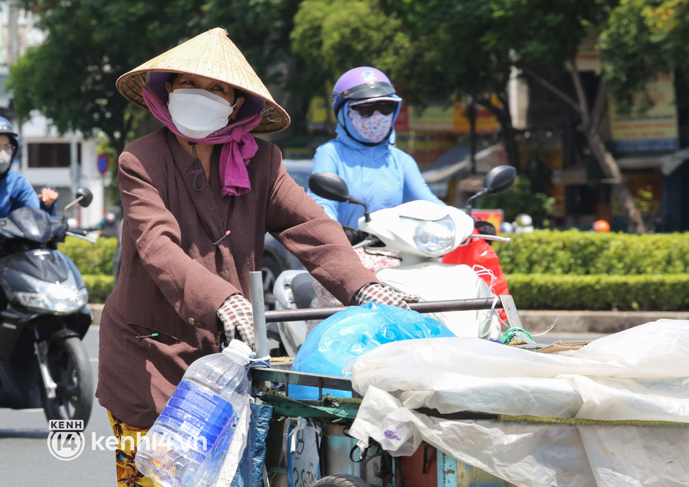 Người dân TP.HCM vật vã dưới nắng nóng hầm hập 34 độ C, ai cũng rát mặt khi ra đường - Ảnh 10.