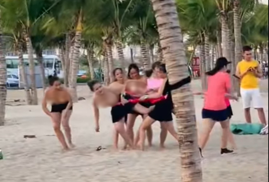 Nhóm phụ nữ để ngực trần chơi team building ở bãi biển Hạ Long - Ảnh 1.