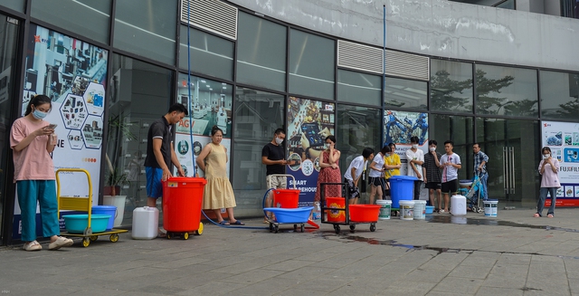  Hà Nội: Người dân mang xô, thùng xếp hàng giữa trưa đợi lấy nước - Ảnh 1.