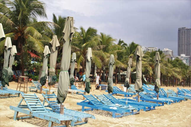 Người dân Đà Nẵng thu dọn hàng quán, hối hả xếp dù trên bãi biển chạy bão - Ảnh 2.