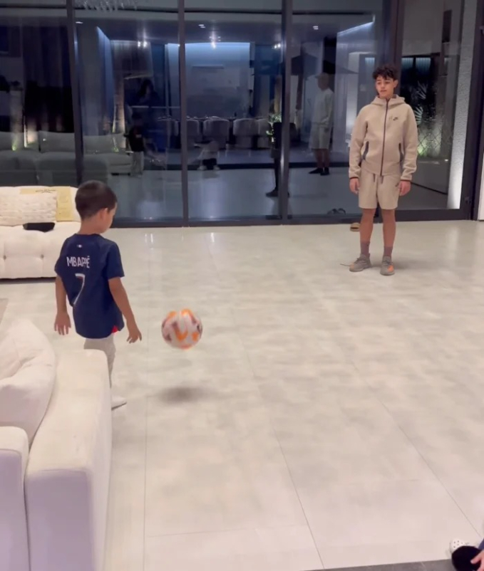 Khoảnh khắc đáng yêu: Ronaldo vừa đeo bờm chuột Minnie vừa chơi bóng cùng con, chiếc áo của một nhóc tì gây chú ý - Ảnh 2.