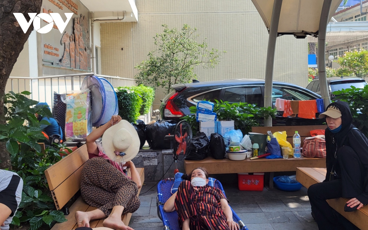 Người bệnh, người nhà mệt mỏi chờ khám dưới cái nắng hơn 40 độ C ở Hà Nội - Ảnh 10.