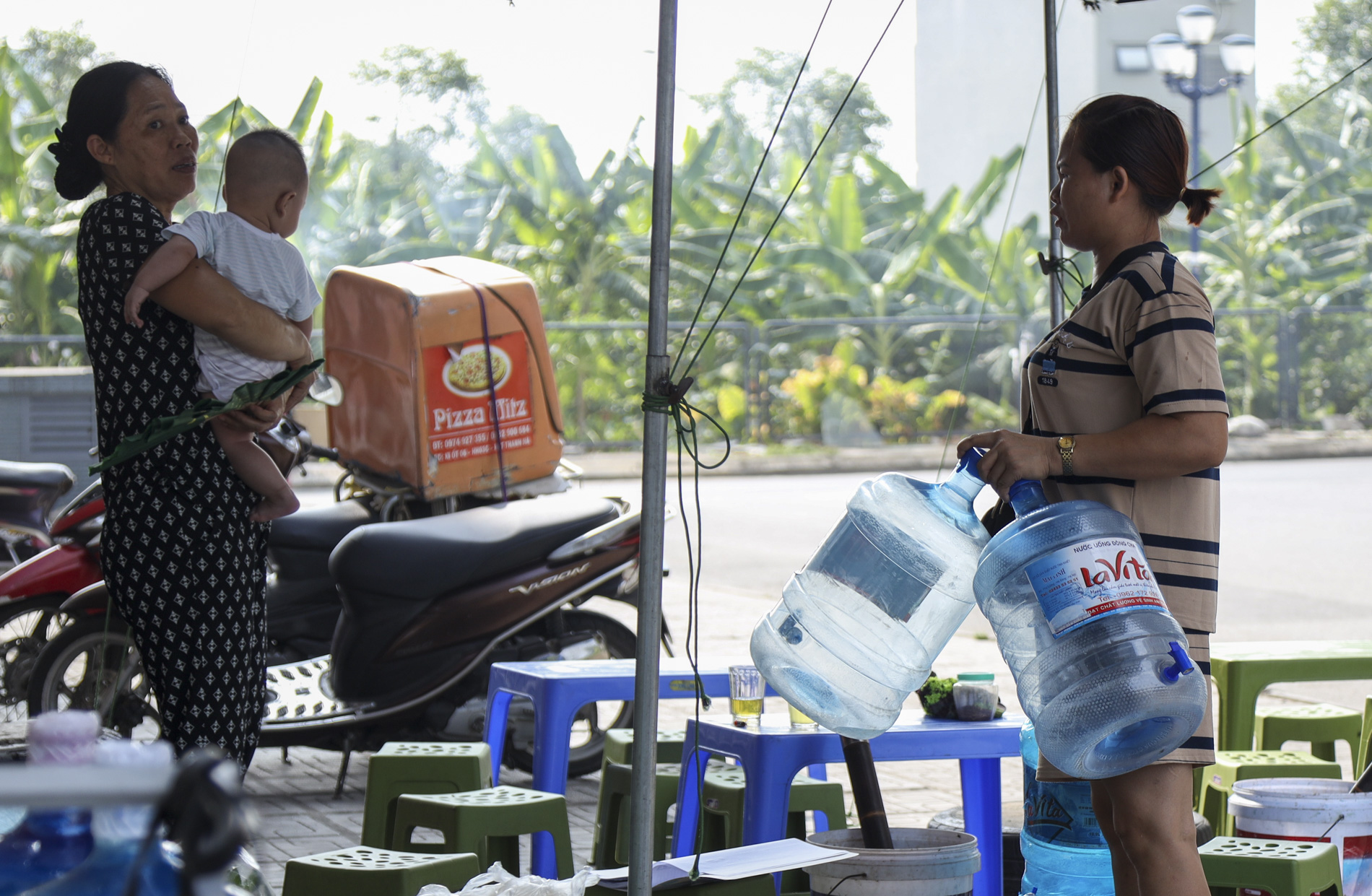 Người dân xách can, thùng nhựa,… đội nắng dưới tiết trời gần 40 độ C để lấy nước sử dụng  - Ảnh 5.