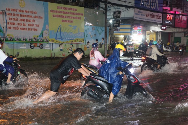 Đường phố TPHCM ngập lênh láng, nước chảy cuồn cuộn sau cơn mưa lớn - Ảnh 5.