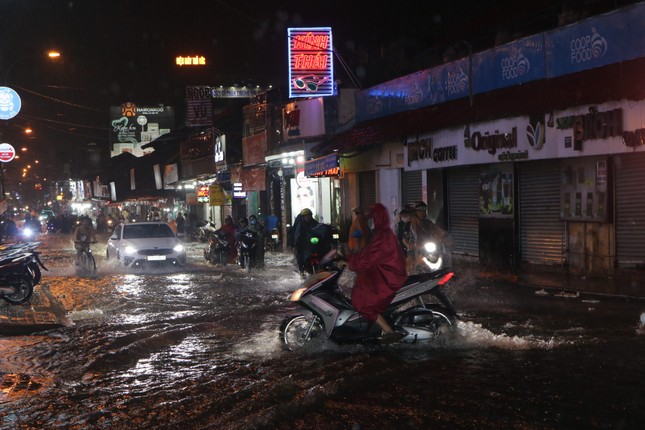 Đường phố TPHCM ngập lênh láng, nước chảy cuồn cuộn sau cơn mưa lớn - Ảnh 7.