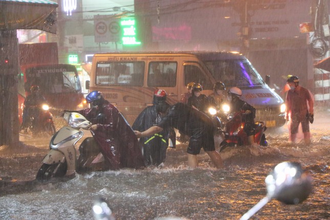 Đường phố TPHCM ngập lênh láng, nước chảy cuồn cuộn sau cơn mưa lớn - Ảnh 2.