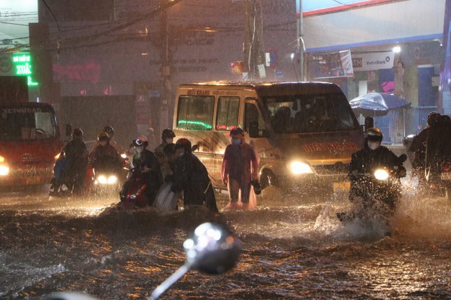 Đường phố TPHCM ngập lênh láng, nước chảy cuồn cuộn sau cơn mưa lớn - Ảnh 3.