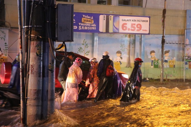 Đường phố TPHCM ngập lênh láng, nước chảy cuồn cuộn sau cơn mưa lớn - Ảnh 4.