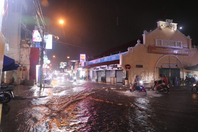Đường phố TPHCM ngập lênh láng, nước chảy cuồn cuộn sau cơn mưa lớn - Ảnh 1.