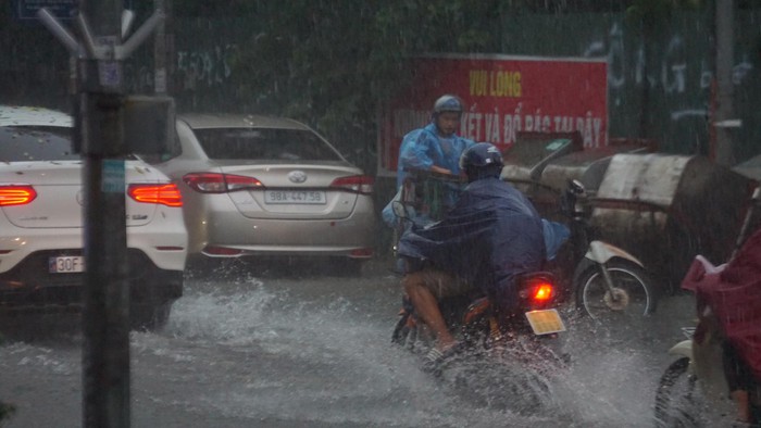 Mưa lớn bất ngờ ở Hà Nội khiến nhiều người trở tay không kịp, xe cộ vật lộn trong nước - Ảnh 7.