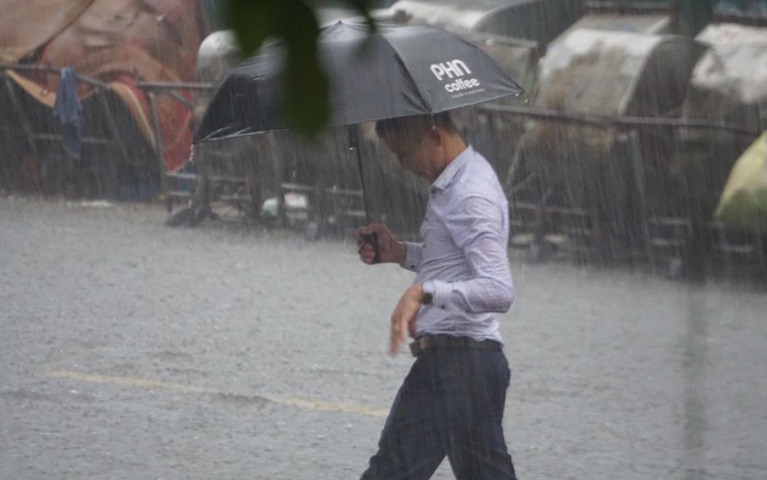 Mưa lớn bất ngờ ở Hà Nội khiến nhiều người trở tay không kịp, xe cộ vật lộn trong nước - Ảnh 4.