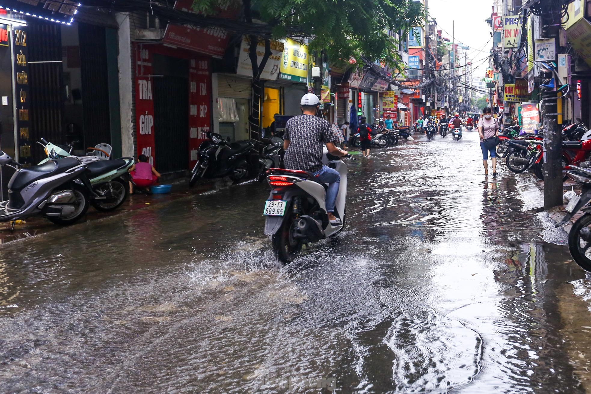 Người dân bì bõm về nhà trên những con phố ngập nước ở Hà Nội - Ảnh 1.