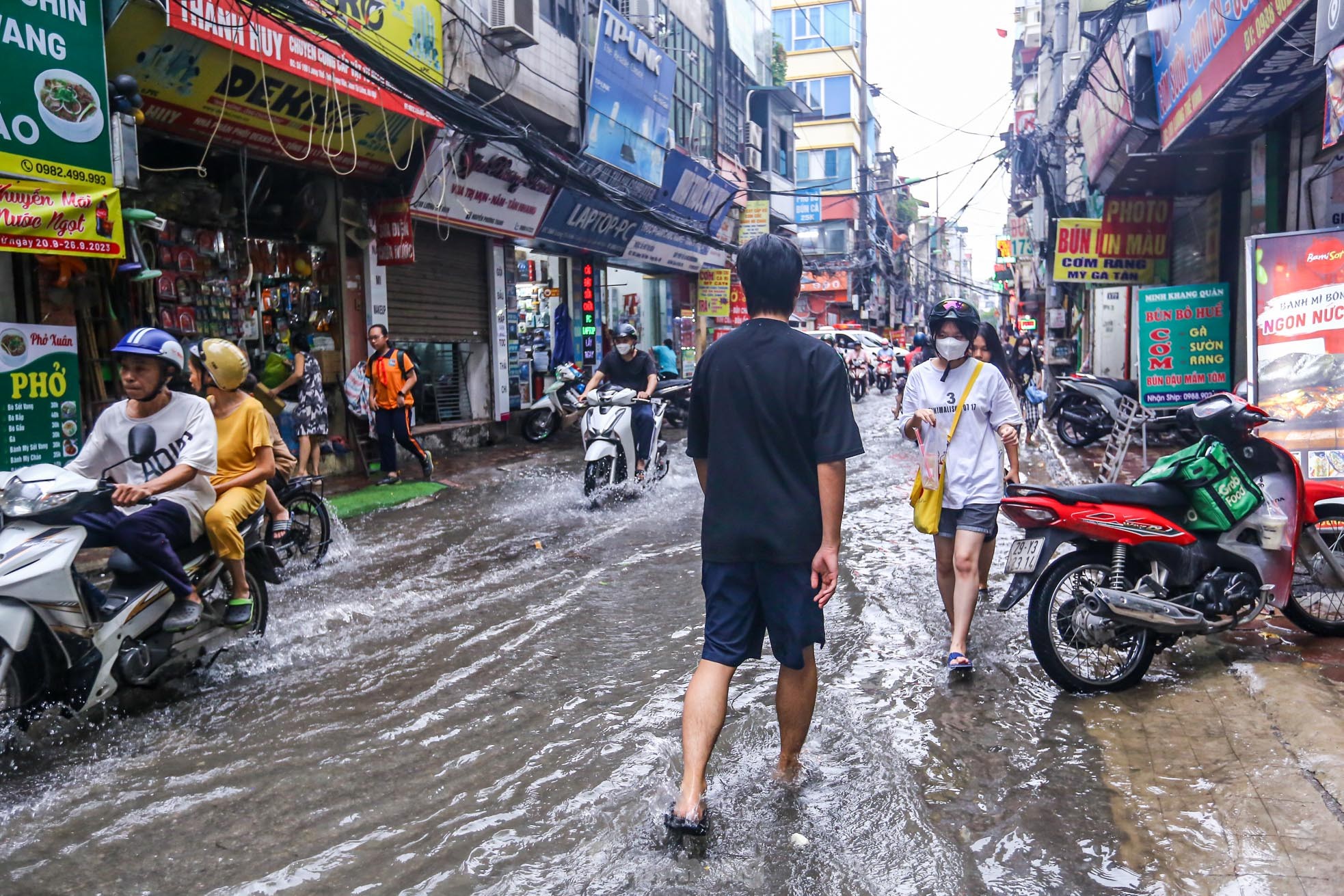 Người dân bì bõm về nhà trên những con phố ngập nước ở Hà Nội - Ảnh 2.