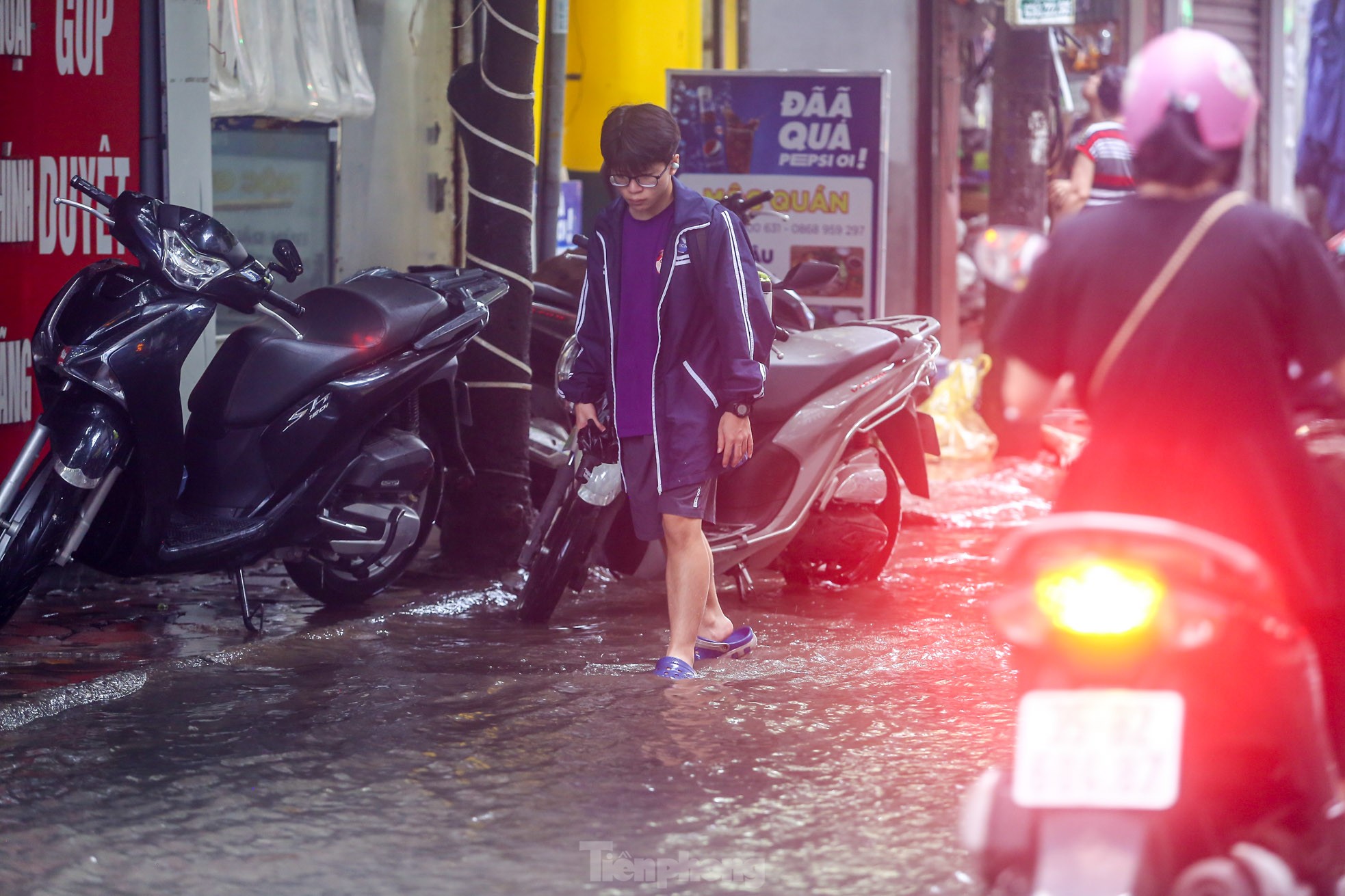 Người dân bì bõm về nhà trên những con phố ngập nước ở Hà Nội - Ảnh 7.