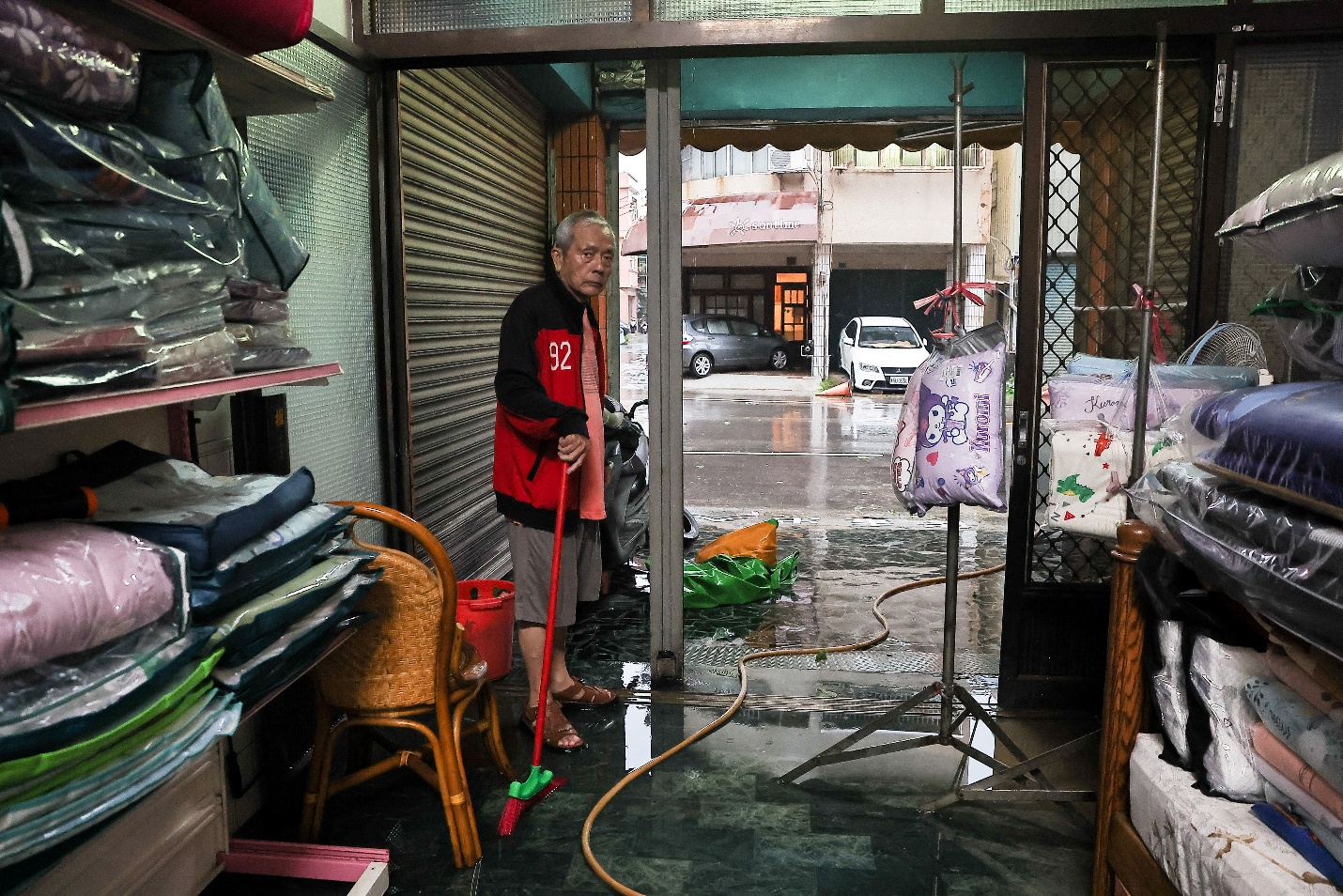 A man cleans the flood inside his store after Typhoon Krathon made landfall in Kaohsiung