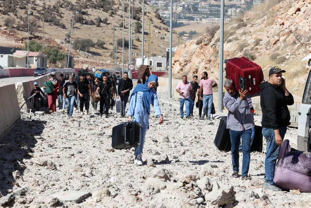 Người dân Lebanon trốn chạy qua cửa khẩu Masnaa (nối với Syria) hôm 4-10, giữa lúc Israel giao tranh với nhóm Hezbollah tại miền Nam Lebanon Ảnh: REUTERS