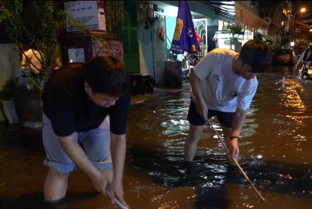 TP.HCM mênh mông nước sau trận mưa trắng trời, kẹt xe khắp nơi, người dân mỏi tay tát nước, thông ống cống- Ảnh 5.