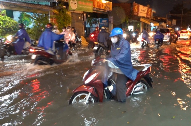 TP.HCM mênh mông nước sau trận mưa trắng trời, kẹt xe khắp nơi, người dân mỏi tay tát nước, thông ống cống- Ảnh 2.