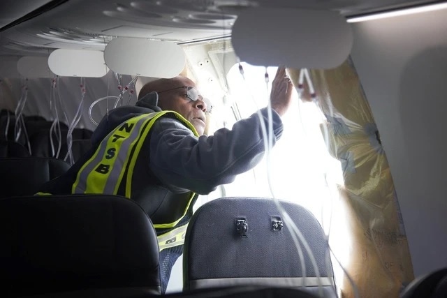 Nhân viên điều tra kiểm tra phần bị thổi bay khỏi máy bay Alaska Airlines. Ảnh: Reuters