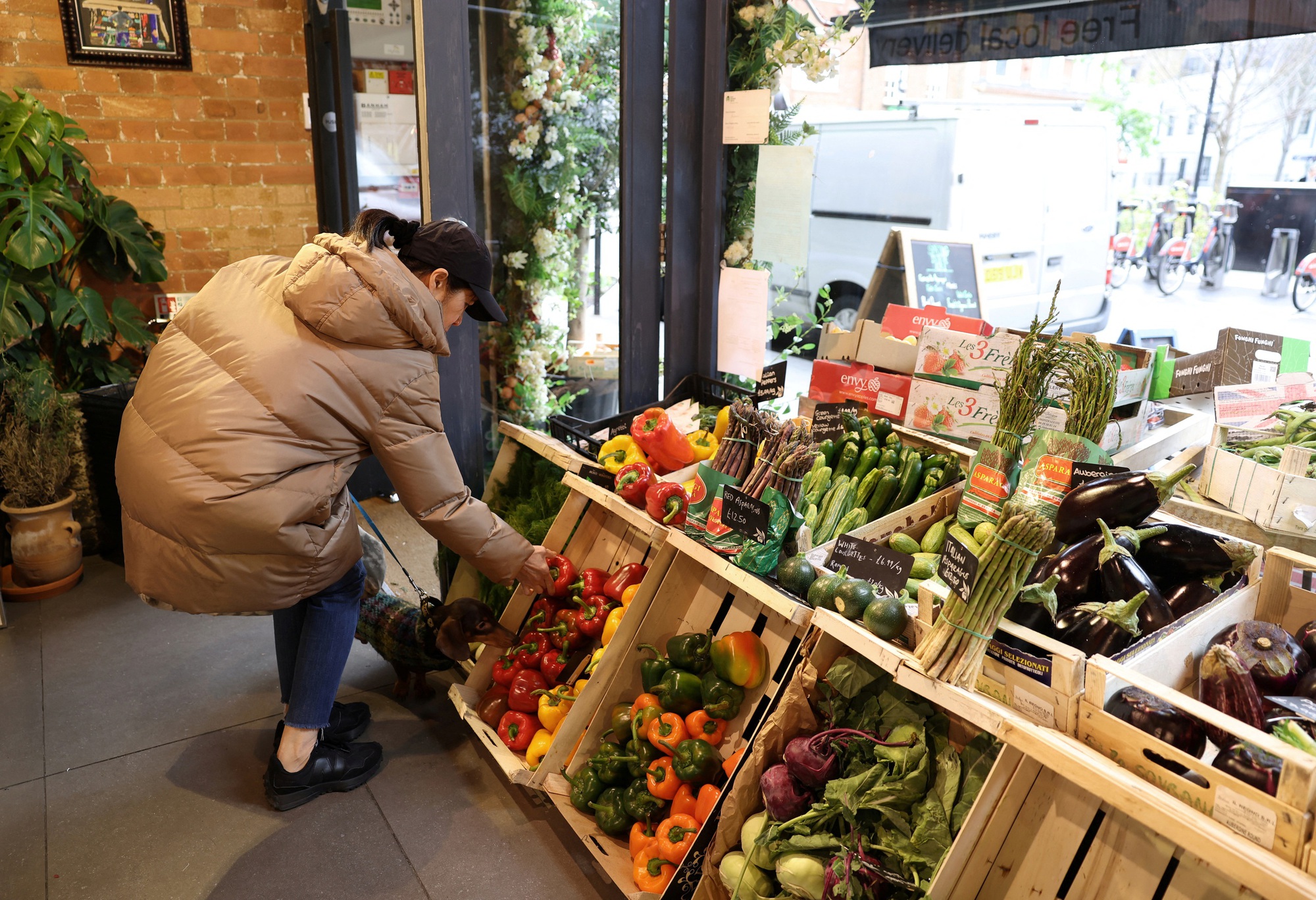 Khách hàng mua rau tại cửa hàng tạp hóa ở London - Anh hôm 28-3 Ảnh: REUTERS