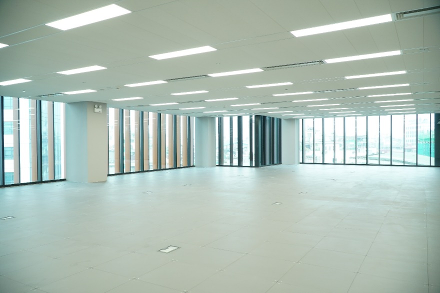 A large empty room with windows  Description automatically generated