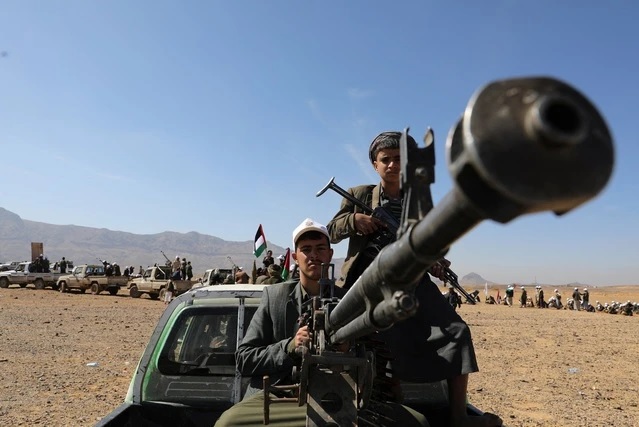 Một người trung thành với Houthi điều khiển súng máy gắn trên xe bán tải trong cuộc diễu hành quân sự ở Yemen hồi cuối tháng 1. Ảnh: Reuters