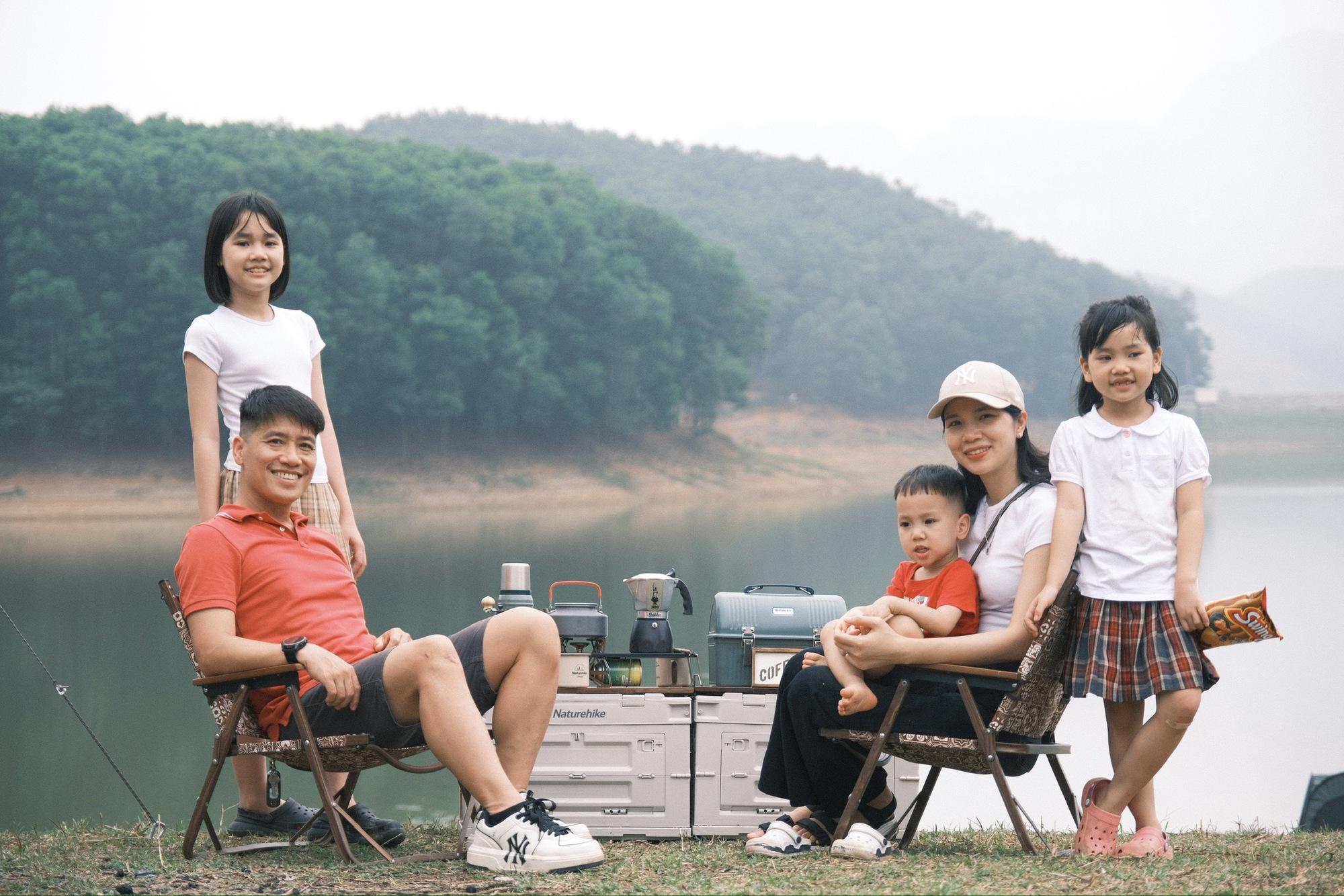 Gia đình nhỏ thưởng thức bữa cơm mùa hè trong chuyến picnic, vừa ăn vừa nghe chim hót, suối chảy róc rách, 