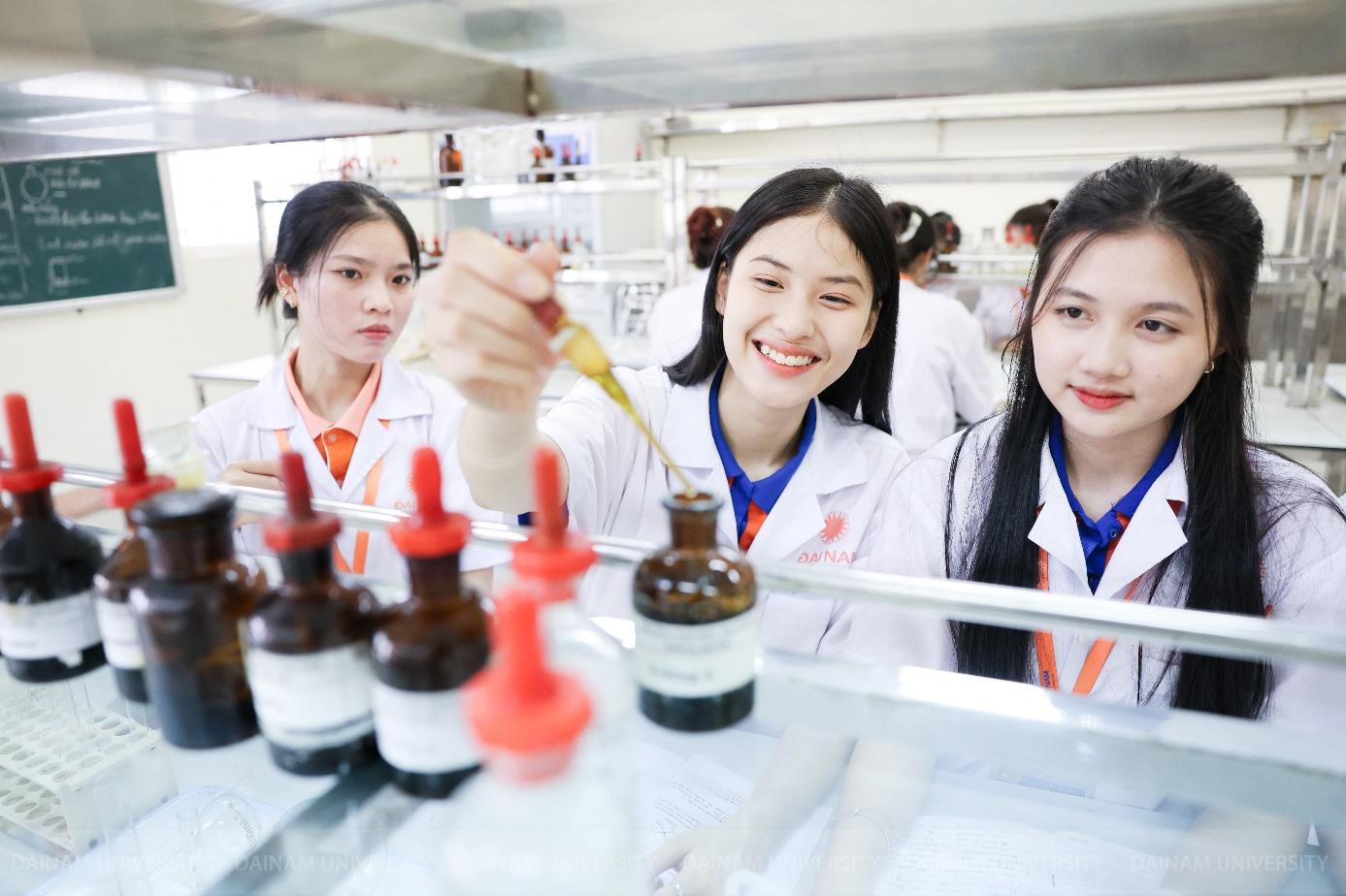 A group of women in lab coats pouring liquid into bottles  Description automatically generated