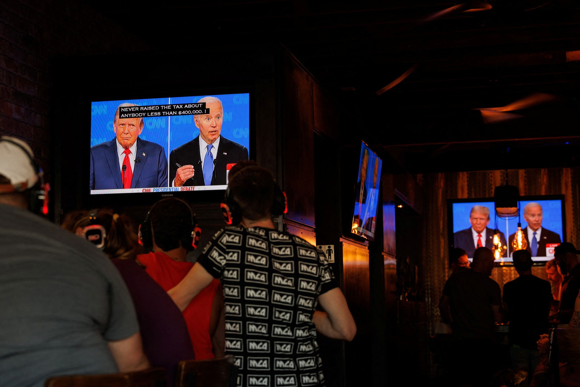 Người dân tại TP San Diego, bang California - Mỹ xem cuộc tranh luận giữa Tổng thống Joe Biden và cựu Tổng thống Donald Trump trên truyền hình hôm 27-6 Ảnh: REUTERS