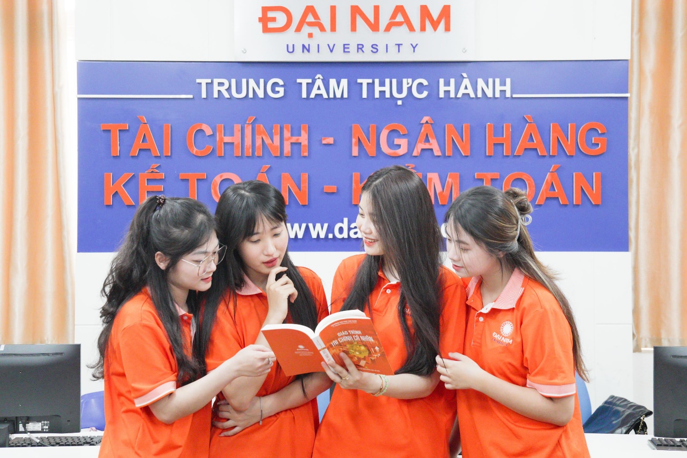 A group of women in orange shirts  Description automatically generated