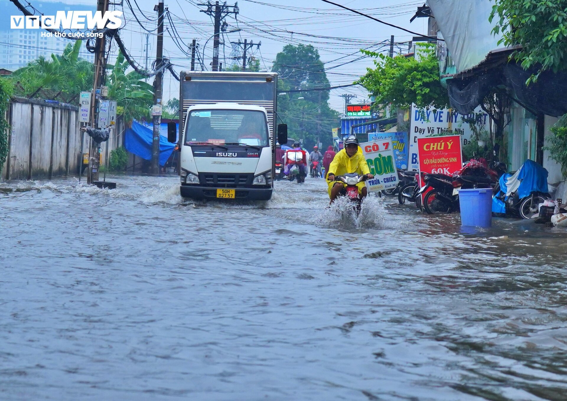 TP.HCM: Mưa kéo dài 5 tiếng, ô tô chết máy, người dân bì bõm lội giữa biển nước- Ảnh 1.