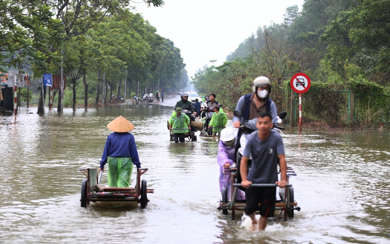 Hà Nội: Ngập sâu trên đại lộ Thăng Long, người dân phải bỏ 50.000 đồng thuê xe bò vượt qua- Ảnh 1.