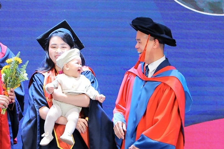Tân thạc sĩ bế con nhận bằng, khoảnh khắc em bé mỉm cười gây 'bão' mạng xã hội- Ảnh 1.