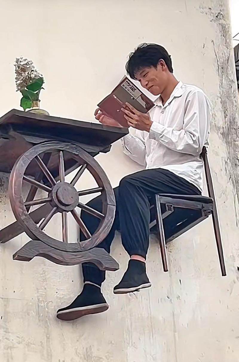 Nam thanh niên làm "logo sống" đọc sách trên cao hút du khách: Công việc kỳ lạ, lương cao ngất ngưởng không ngờ- Ảnh 1.