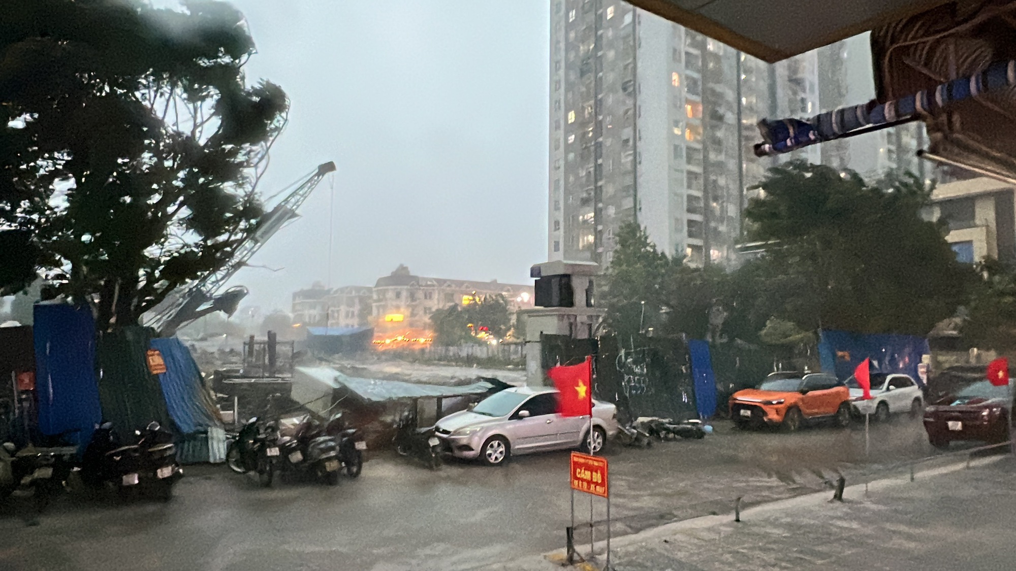 Hà Nội mưa dông mạnh, gió thổi bạt người đi xe máy, trời tối sầm rồi mưa như trút- Ảnh 2.