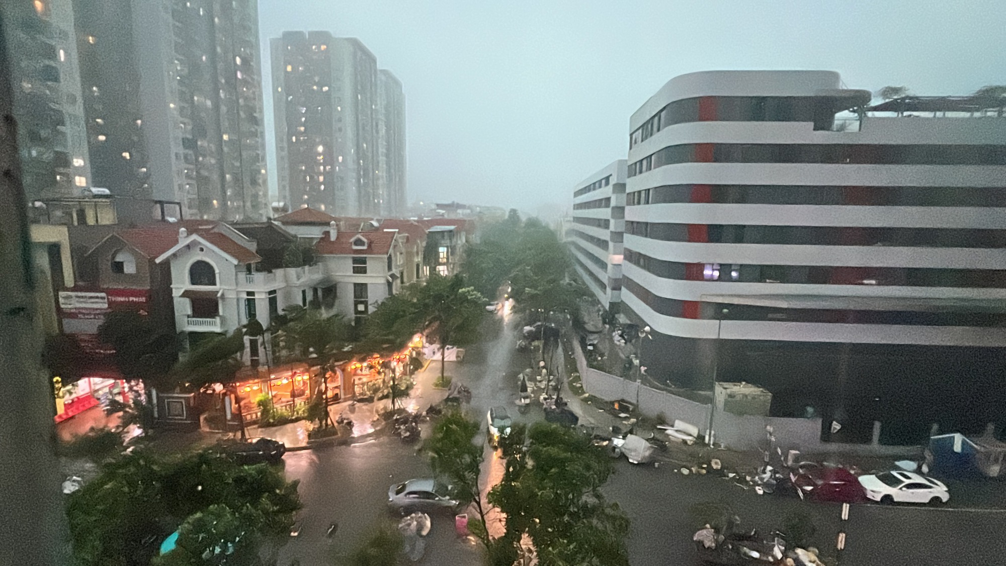 Hà Nội mưa dông mạnh, gió thổi bạt người đi xe máy, trời tối sầm rồi mưa như trút- Ảnh 1.