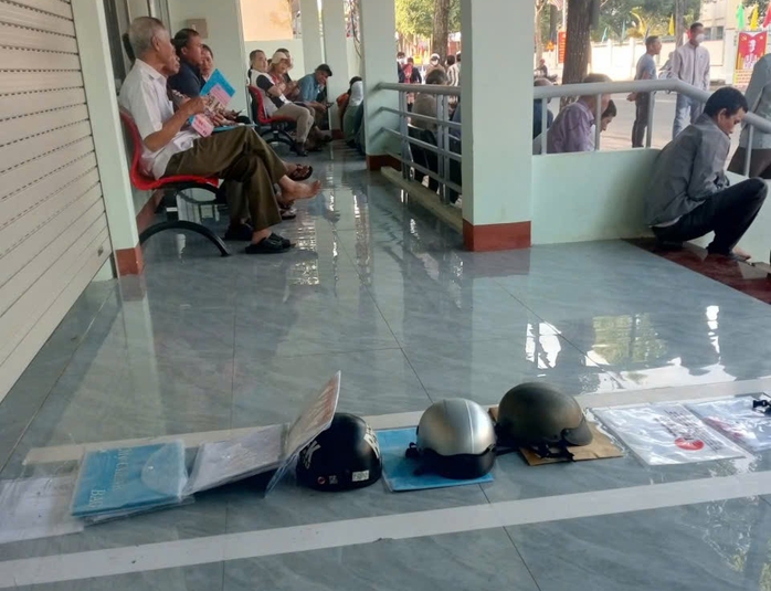 Lãnh đạo xã nói gì về việc người dân đặt nón bảo hiểm"xếp hàng" làm thủ tục hành chính?- Ảnh 1.