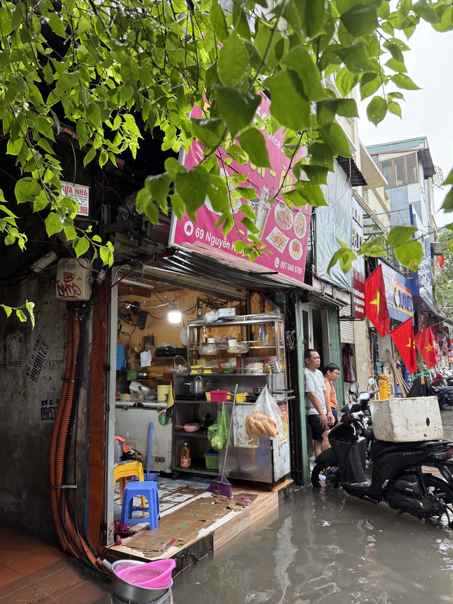 Loạt hàng quán ngập nước vẫn mở cửa, trở thành chỗ trú cho khách giữa thời tiết mưa lớn ở Hà Nội- Ảnh 3.