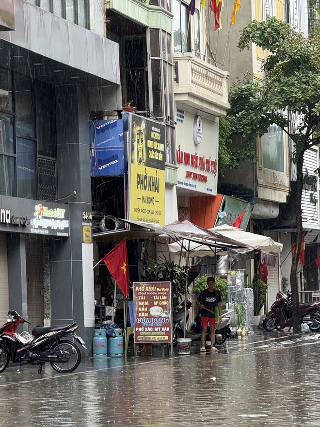 Loạt hàng quán ngập nước vẫn mở cửa, trở thành chỗ trú cho khách giữa thời tiết mưa lớn ở Hà Nội- Ảnh 4.