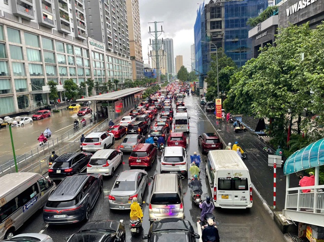 Hà Nội mưa to do ảnh hưởng bão số 5, đường phố ngập nặng, giao thông ách tắc- Ảnh 12.