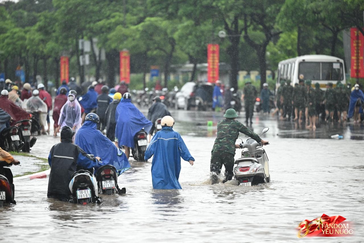 Ảnh đẹp sáng nay: Các chiến sĩ làm nhiệm vụ A80 lội nước đẩy xe, dìu dân qua đoạn ngập sâu ở Hà Nội- Ảnh 1.