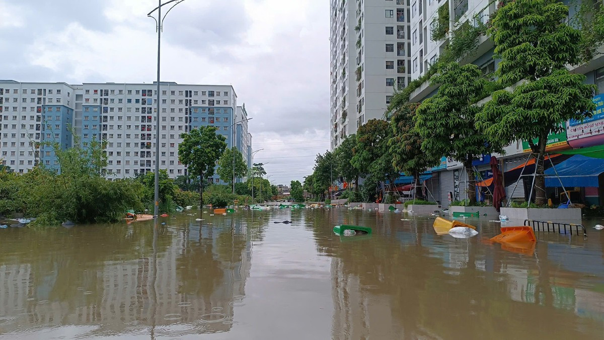 Nhiều khu chung cư Hà Nội thành 'ốc đảo' sau mưa lớn, dân dựng đập ngăn nước tràn vào hầm- Ảnh 1.
