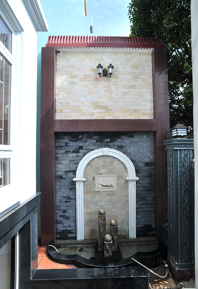 Một đài phun nước nhỏ được bố trí ngay cạnh cổng vào nhà.